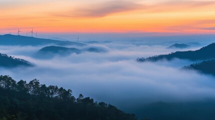 Fototapeta premium Beautiful fog mountain landscape and wind generators turbines at sunset, Khao Kho mountain, Thailand. Renewable energy concept.