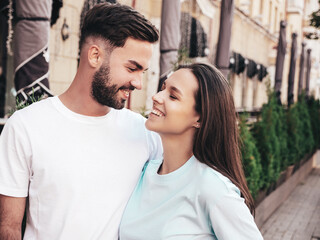 Naklejka premium Smiling beautiful woman and her handsome boyfriend. Woman in casual summer jeans clothes. Happy cheerful family. Female having fun. Sexy couple posing in the street at sunny day . In sunglasses