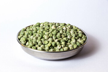 A plate filled with natural whole dried green peas and organic dried green peas. Isolated on a white background.