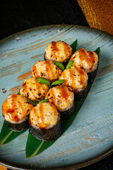 Sushi rolls with savory toppings rest elegantly on a textured blue surface