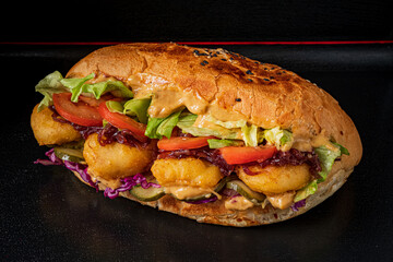 Hearty sandwich brimming with crunchy fritters, fresh veggies, and zesty sauce, perfect for lunch