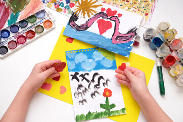 Child painting flowers, couple swan, hearts, making crafts from paper. Handmade concept for birthday, mothers day or Valentines day. Education. Inspiration and imagination