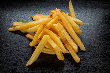 Delicately arranged crispy fries glimmering under soft light, inviting hunger and delight