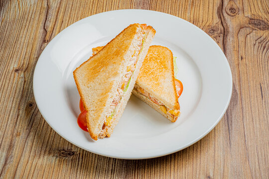 A delightful sandwich cut in half, showcasing layers of savory fillings and crisp vegetables