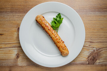 A perfectly grilled sausage rests on a pristine white plate, accented by fresh parsley
