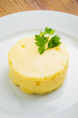A delightful butter sits elegantly on a plate, topped with vibrant parsley