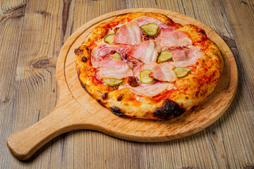 Savor the vibrant flavors of fresh pizza adorned with savory ham, crunchy pickles, and zesty onions