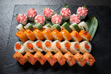 Artfully arranged sushi types on a slate board, showcasing their freshness