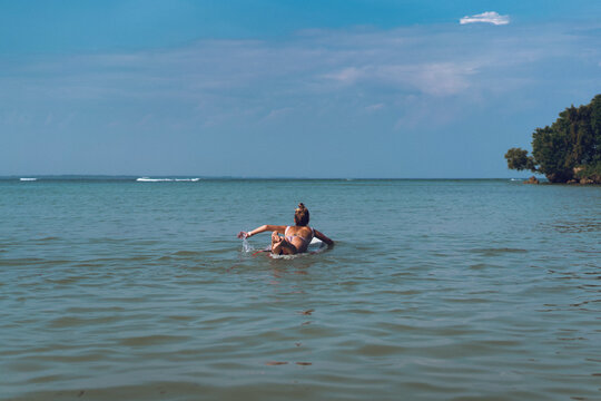 Happy wet woman surfing in the ocean