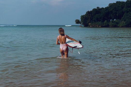 Happy wet woman surfing in the ocean