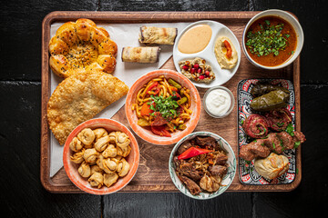 Colorful variety of traditional dishes presented on a wooden tray, showcasing culinary diversity
