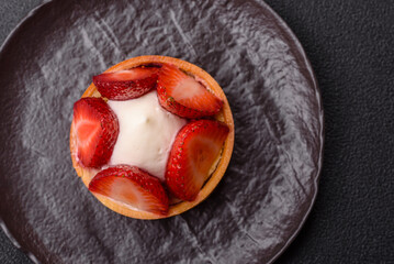 Round sweet tart with strawberry pieces and cream