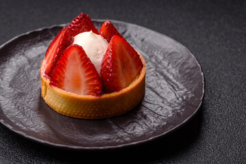 Round sweet tart with strawberry pieces and cream