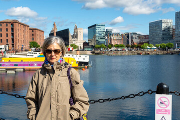 Senior tourist enjoying liverpool docks on sunny day