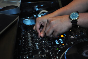 close up of a disk jockey's hands playing at his table