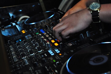 close up of a disk jockey's hands playing at his table