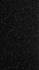 Coarse grit surface in dark tones, highlighted with irregular light-reflective granules.