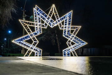 Illuminated geometric star structure at night in a park