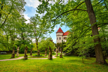 Konopiste castle, surrounded by stunning gardens and lush green trees, showcases beautiful statues...