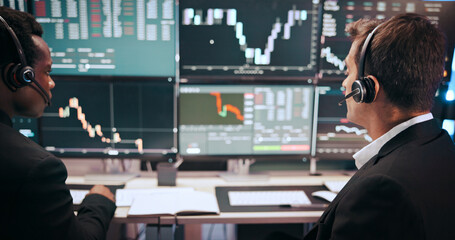 Men, monitor and graphs for stock market, together and voip headset for consulting at investment agency. Business people, partner and back with charts for profit, revenue and trading by pc screen