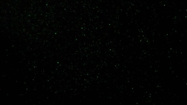 Small green colored fireflies dots random movement flying on black looped motion copy space background.