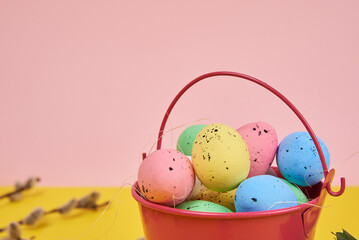 Easter eggs in a bucket on a pink background