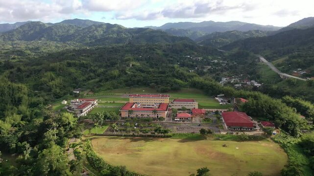 Drone view of UPR - University of Puerto Rico in Utuado surrounded by green spaces and lush hills