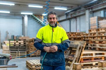 Portrait of a mature worker in a pallet recycling plant