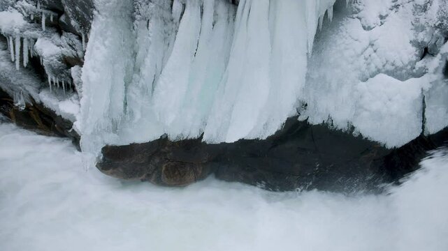 Frozen Icicles Above Raging Waterfall