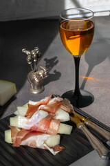 A delicious appetiser of melon and Parma ham or jamon, served with wine in a hard light.