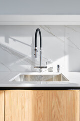 Modern kitchen sink design with sleek flexible faucet and natural wood cabinetry