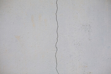 Close-up of a white wall cracked into lines.