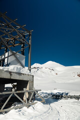 Cable car station. Wide angle view of monolithic cable car structure in snowy mountains in cloudless weather