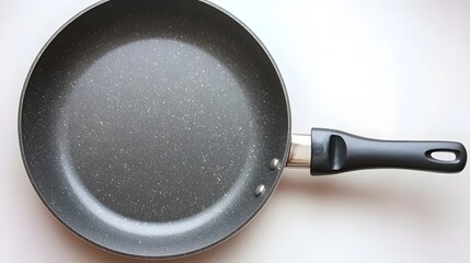 Nonstick Black Frying Pan with Speckled Surface and Sturdy Handle in Home Kitchen Setting