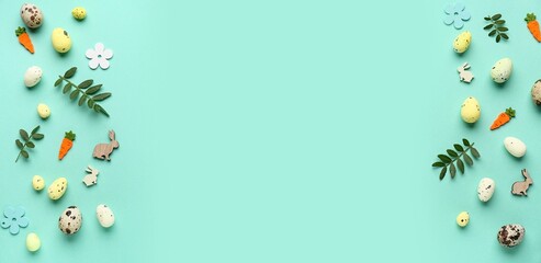 Green leaves, Easter eggs and decorations on turquoise background with space for text