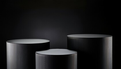 3 black cylindrical podiums on a black heritage