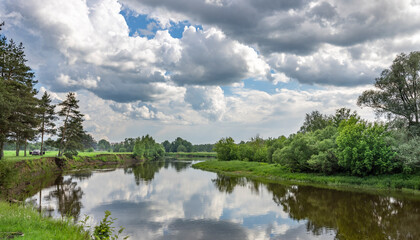 A calm river with a cloudy sky in the background