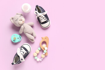 Stylish baby shoes with bottle of milk, toy, pacifier and rattle on purple background