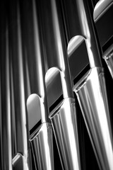 Organ pipes on the façade of a large church organ. Huge pipes made of stainless steel with a matt,...