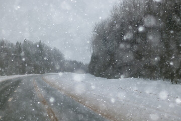 snowfall on a winter road, abstract background, blurred highway backdrop snowy landscape