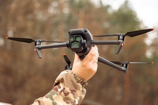 Concept of using drones in modern warfare. Close-up of a drone in hands of a soldier