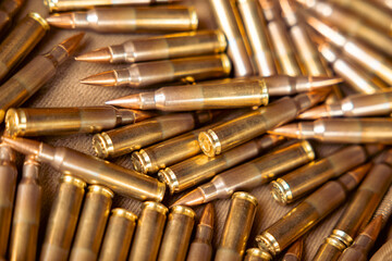 Pile of bullets with copper tips under a warm light. Close up of a lot of bullets. Gun violence