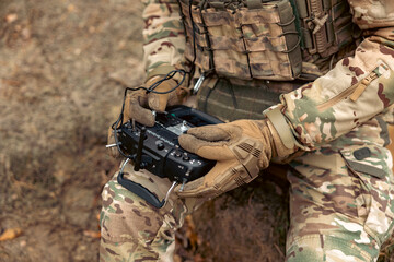 A soldier remotely controls a drone. Control panel in hands.