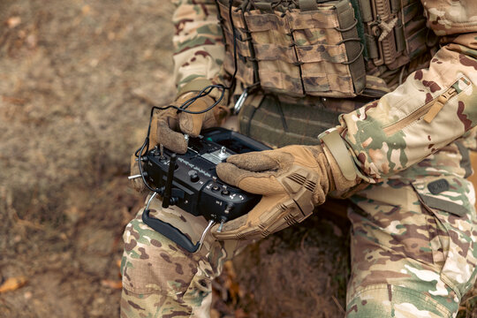 A soldier remotely controls a drone. Control panel in hands.