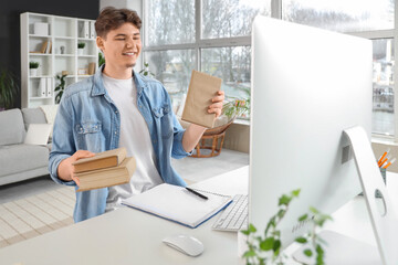 Male student with books studying online at home