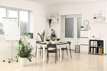 Interior of modern office with workplace, door and plants