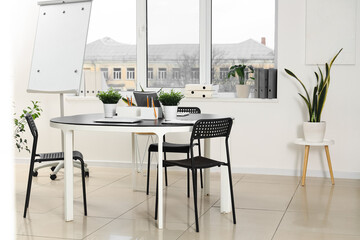 Interior of modern office with workplace, window and plants