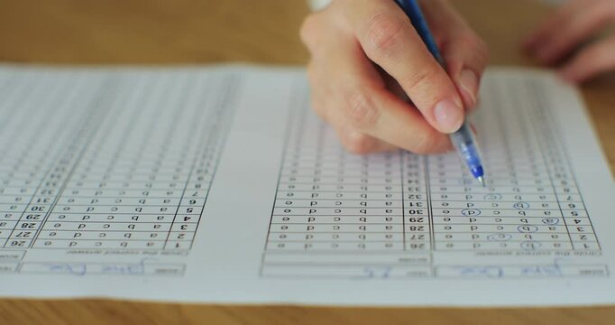 School or university woman students hands taking exams, writing examination room with holding pencil on optical form answers paper sheet.