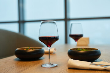 Close-up of dining table with food and red wine in the restaurant