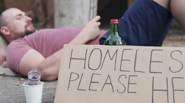Homeless man with a sign please help dreams of his own house. Concept of unemployment and crisis.